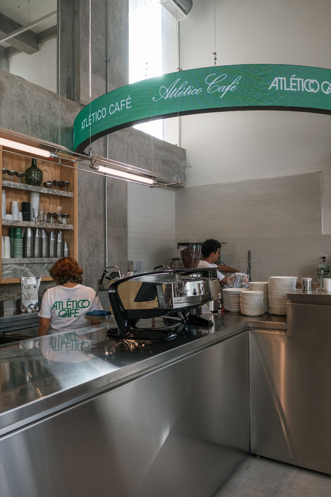Baristas at work under the green Atlético Café sign