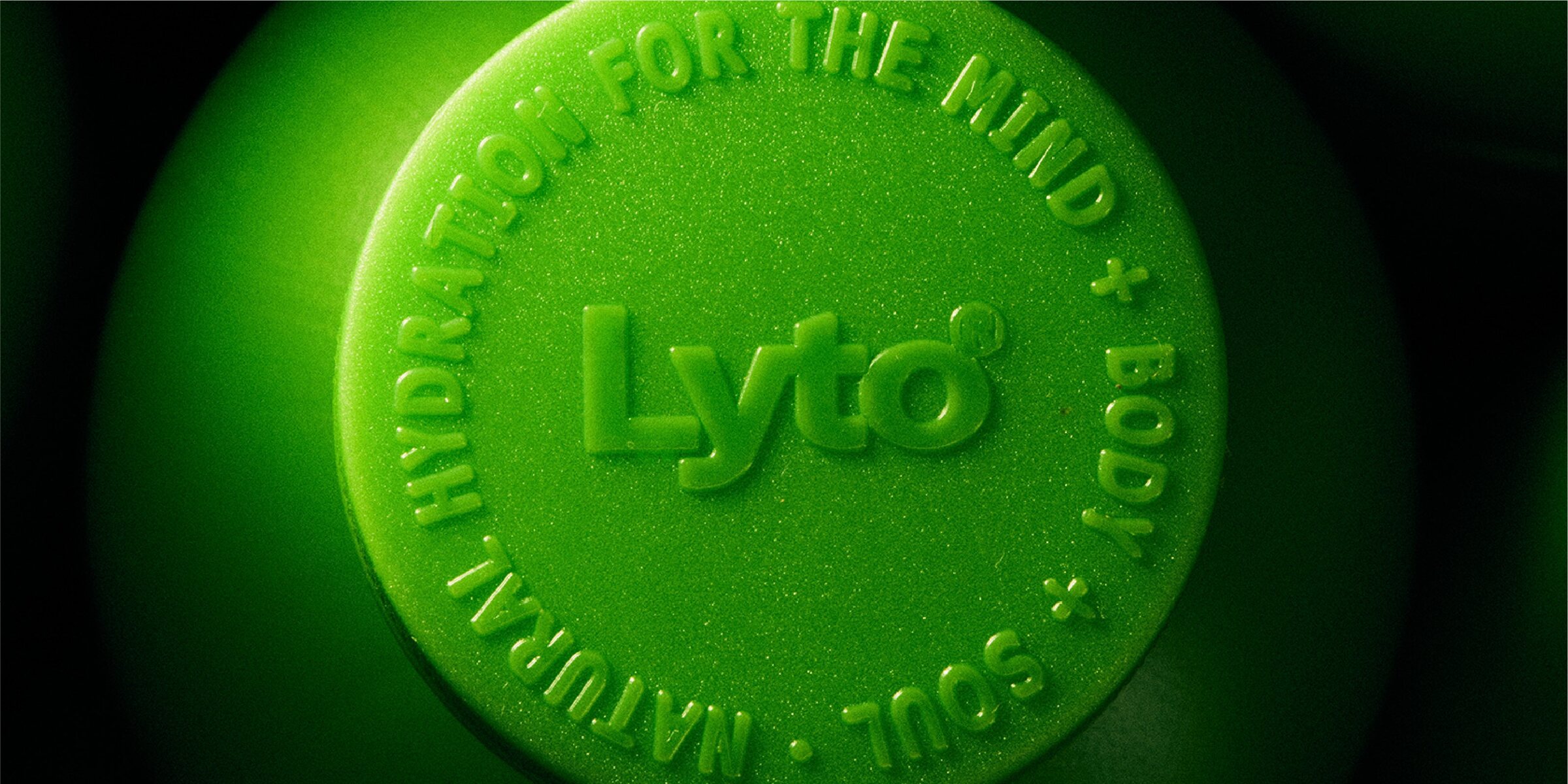 Macro of a green Lyto cap embossed with Natural hydration for the mind + body + soul