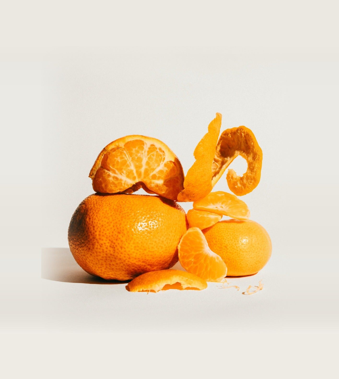 Peeled mandarins stacked on a light background