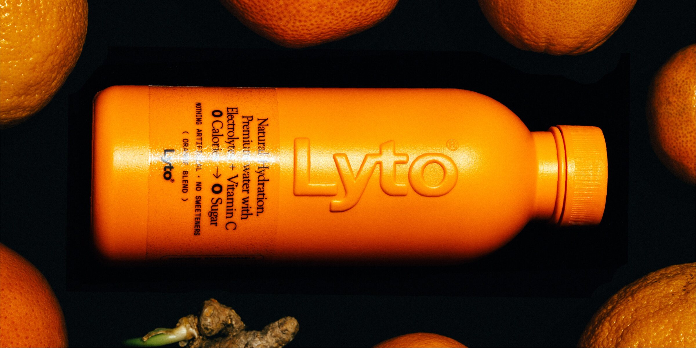 Orange Blend bottle lying among oranges and ginger
