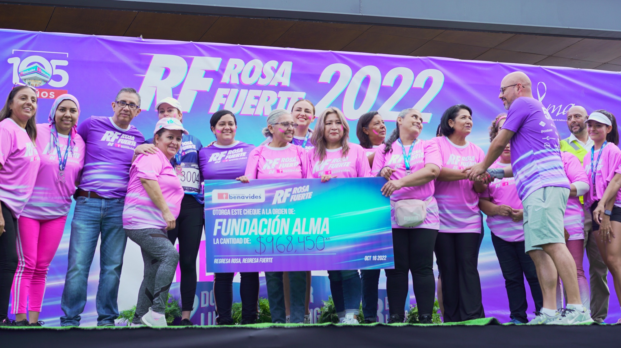 Survivors and the Benavides team on stage with the donation check for Fundación Alma, 2022